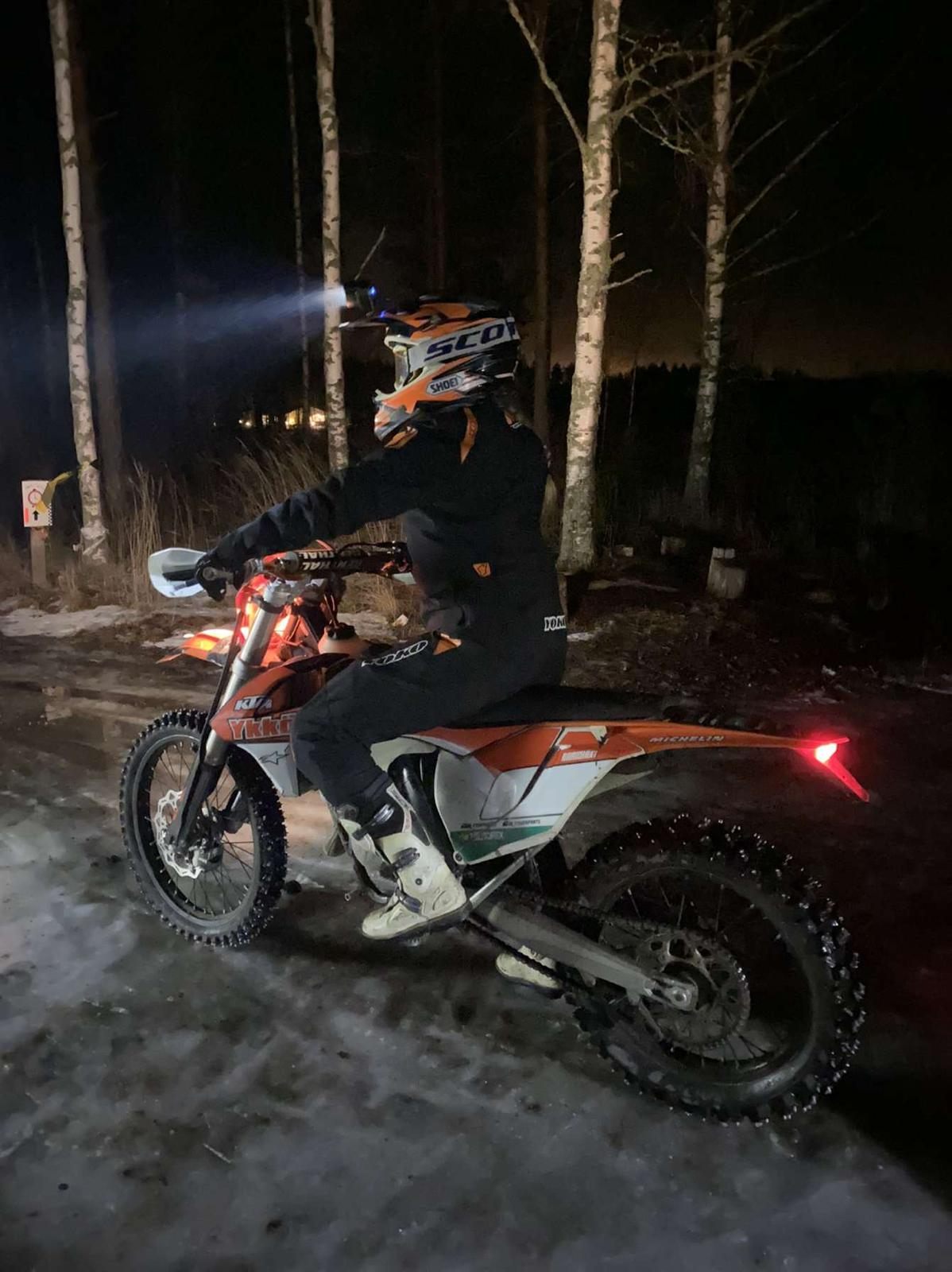 Enduropyörä yöajossa otsalampun valossa