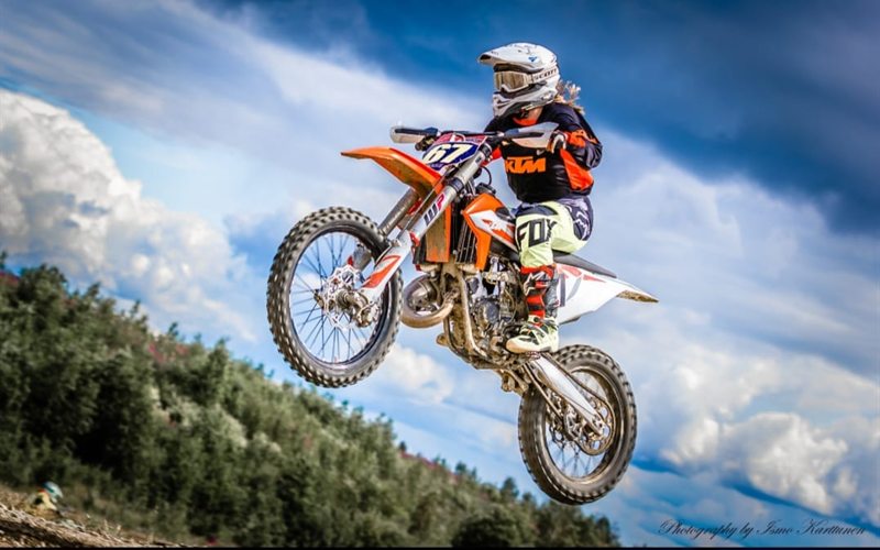 Motocross-ajaja ilmassa, keula ja takajousitus näkyvissä