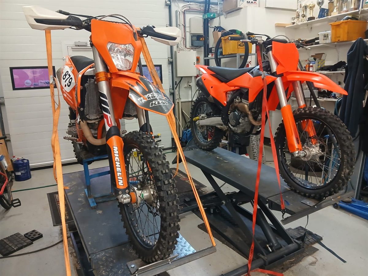 Kaksi enduropyörää nostimilla pajalla