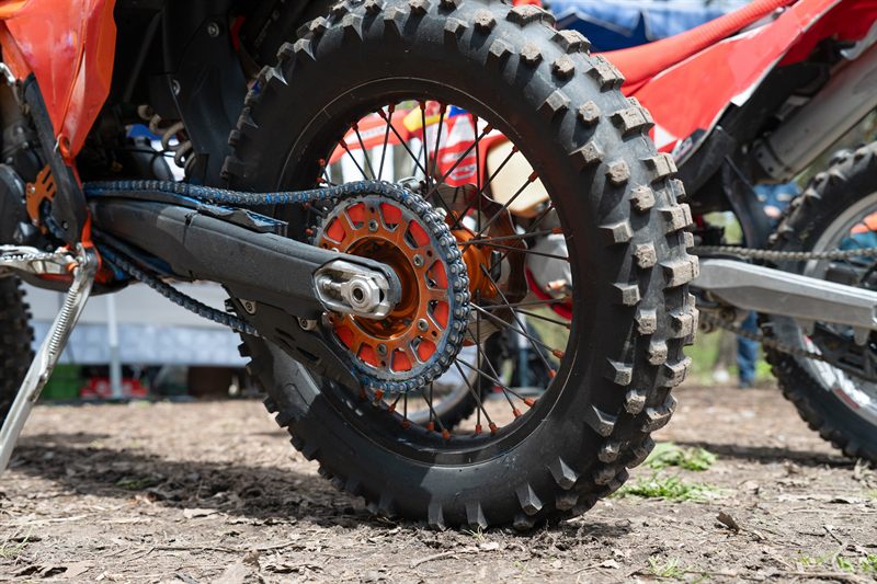 Enduropyörän takapyörä, keinuvarsi ja ketju lähikuvassa